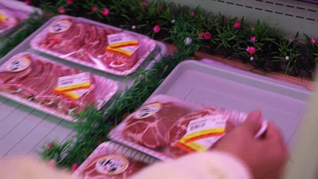 식료품점에서 골라 든 돼지고기 팩