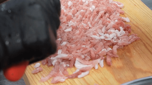 나무 도마 위에서 고기 다지기