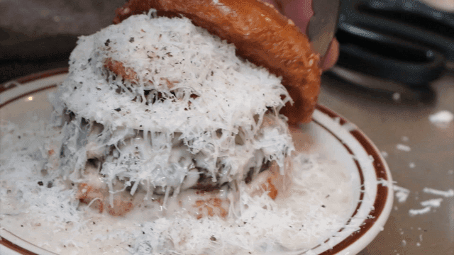 치즈로 덮인 버거를 준비하는 장면