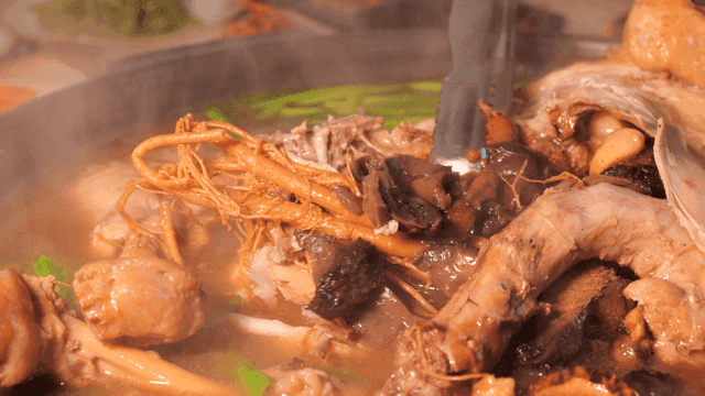 Black garlic ginseng chicken soup, tongs for shredding ginseng and chicken