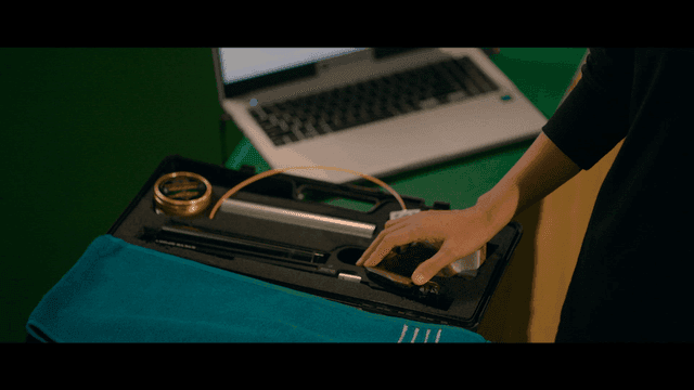 Person touching sports shooting pistol near laptop