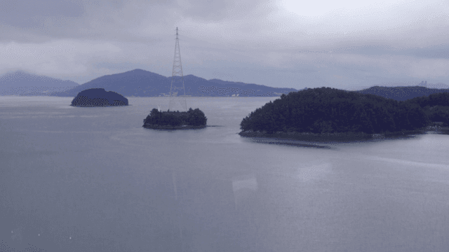 작은 섬과 흐린 하늘이 있는 잔잔한 바다