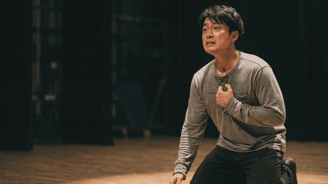 Male actor crying sadly on stage