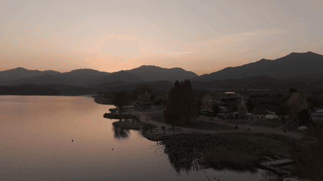 Quiet lake where sun sets over mountains.