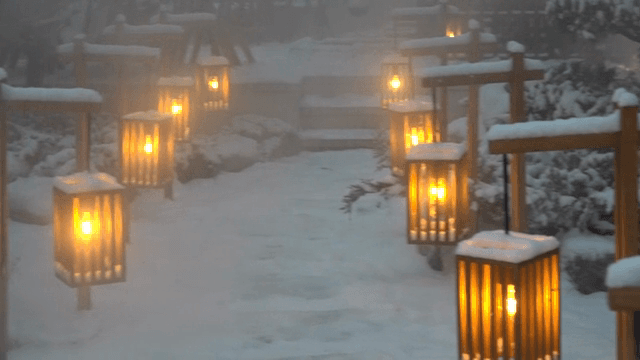 Snow-covered garden with glowing lanterns
