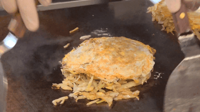 Cooking okonomiyaki on a hot griddle