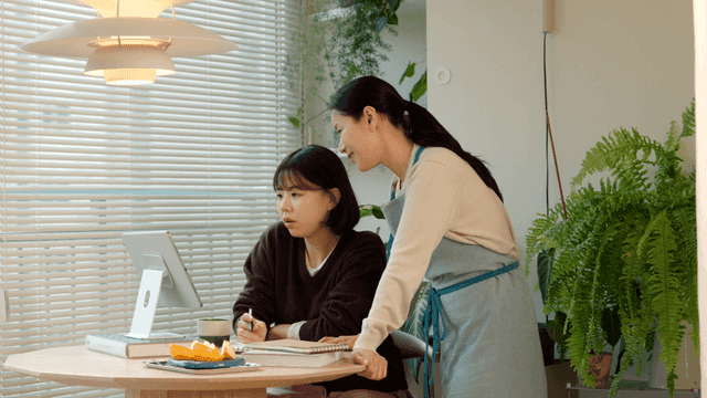 Mother and daughter talking while looking at tablet PC