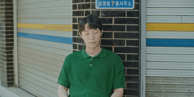 남자가 벽돌 벽에 기대어 있는 모습