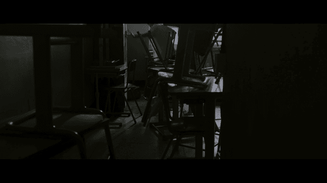 School violence in dark classroom with stacked chairs
