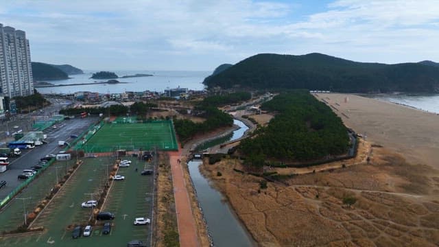 해변과 녹색 언덕이 있는 해안 도시