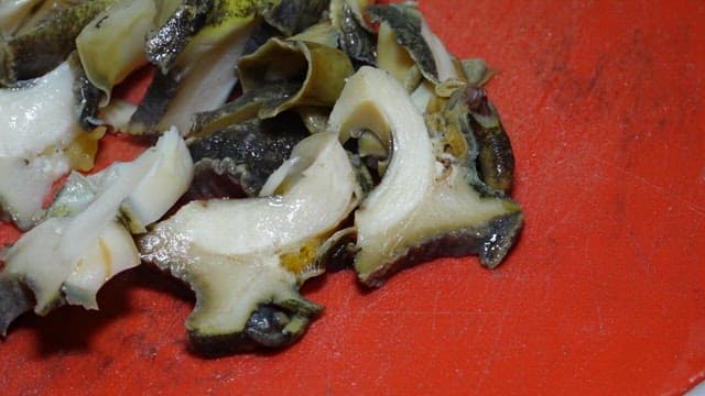 도마 위에서 칼로 신선한 전복을 써는 모습