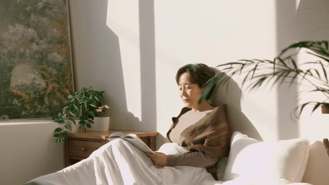 Woman reading a book in a sunlit room