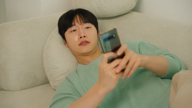 Man lounging on a couch using a smartphone