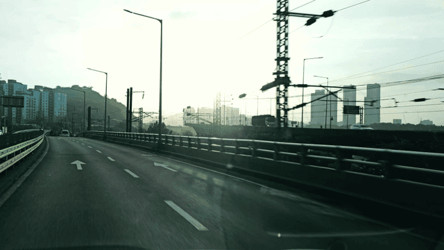 Vehicles driving on road with view of city landscape