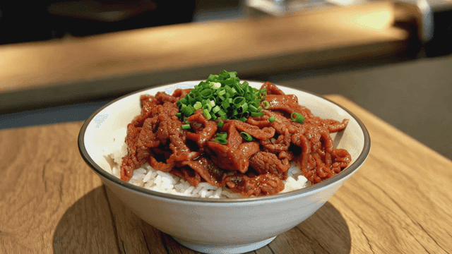 Gyudon, beef rice bowl topped with green onions