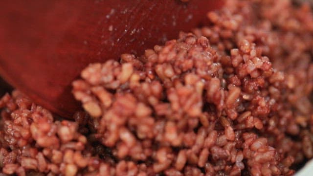 나무 주걱으로 익은 현미밥 저어주기