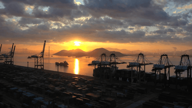 Sunset over a busy port with cranes