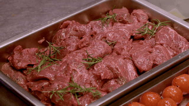 Raw meat with rosemary in a tray