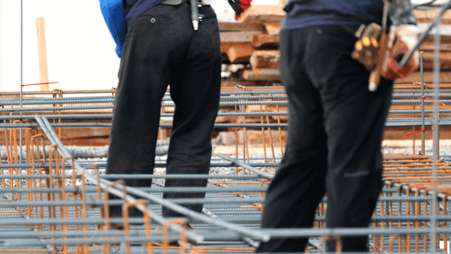 Construction workers handling rebar