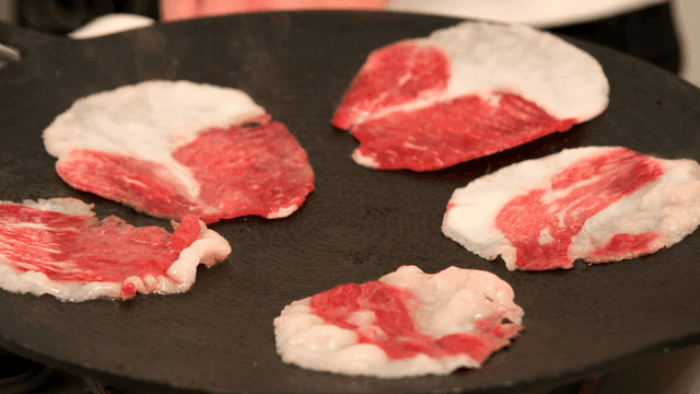 Sizzling beef slices on hot grill