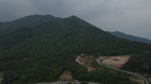 흐린 날 숲이 우거진 산의 풍경