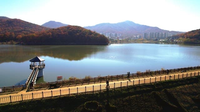 Beautiful Baegunhosu Lake with autumn trees and a view of the walking trail of people