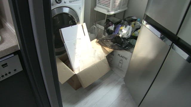 재활용품과 빨래 바구니가 가득한 어수선한 세탁실