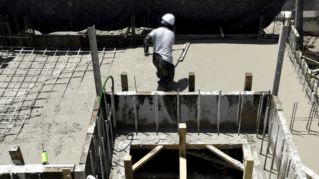 건설 현장에서 콘크리트를 고르는 작업자