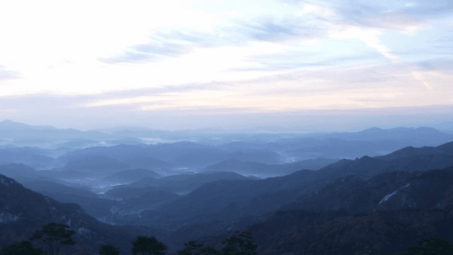 안개 낀 하늘과 새벽의 산맥