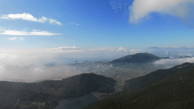 Cityscape surrounded by mountains and clouds
