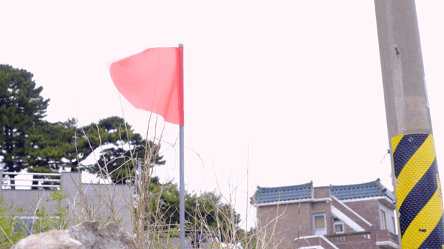 시골 전봇대 근처에서 흔들리는 빨간 깃발