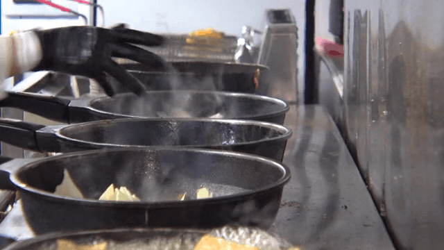 여러 팬이 스토브에서 김을 내며 요리 중