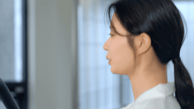 헬스장에서 러닝머신을 뛰는 여성의 옆모습