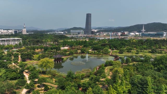 연못과 도시 스카이라인이 있는 푸른 공원