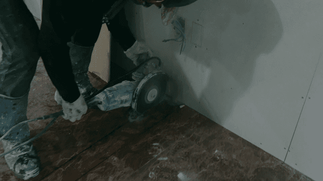 Worker cutting floor with a power tool