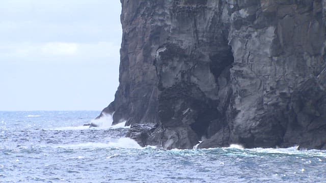 Waves Crashing Against Rugged Cliffs