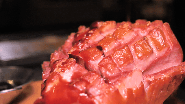 Glazed ham with sauce being poured