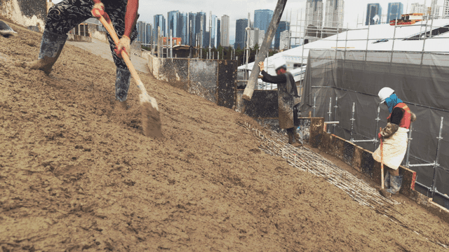 건설 현장에서 콘크리트를 붓는 작업자들