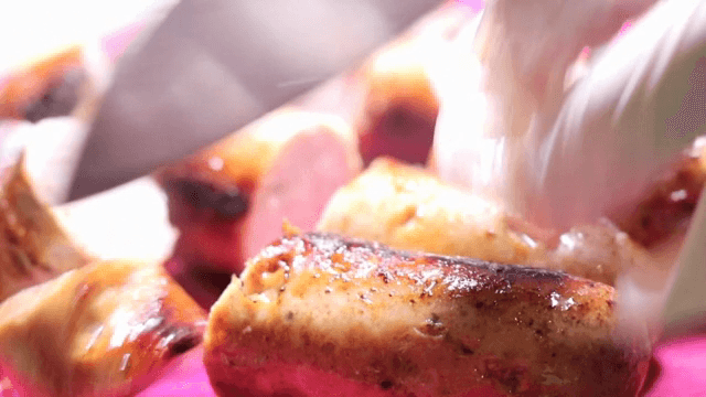 Sausages being sliced with a knife