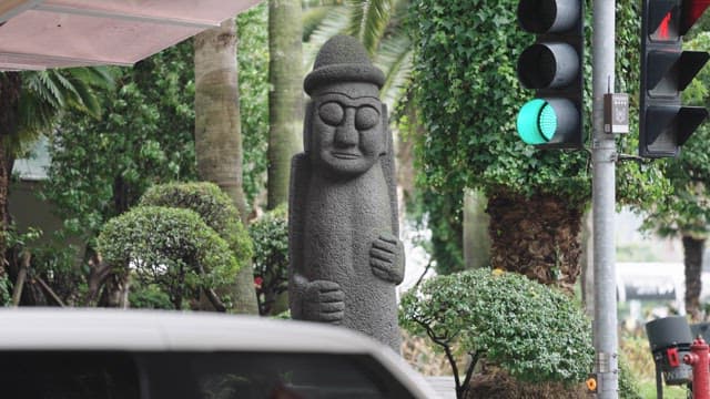 신호등 옆에 세워진 돌하르방 석상