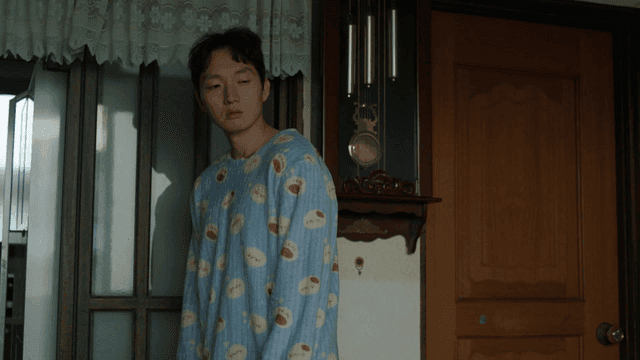 Man coming out of room wearing pajamas