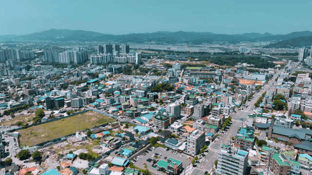 Panoramic view of city with mountains in distance.