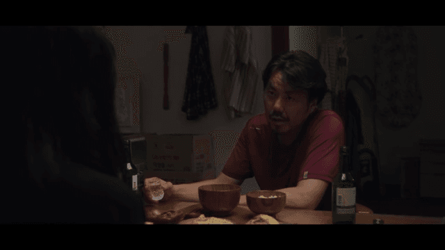 어두운 주방에서 술을 마시는 남성