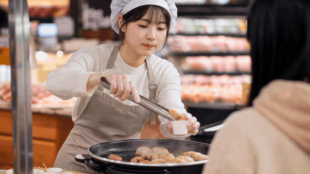 마트에서 시식 만두를 건내는 여성