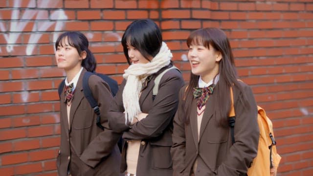 벽돌 담을 따라 걷는 학생들