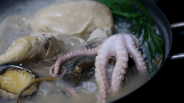 A pot of boiling chicken and seafood