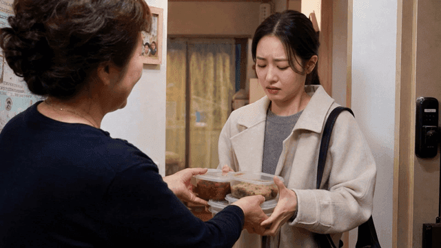 Young woman receiving food from her mother at home