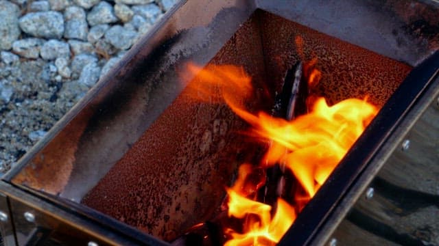 Cooking lamb chops over an flame on the portable stove