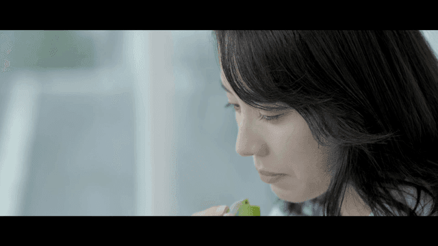 Woman lost in thought while eating green cookies