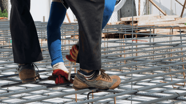 건설 현장에서 철근 위를 걷는 작업자